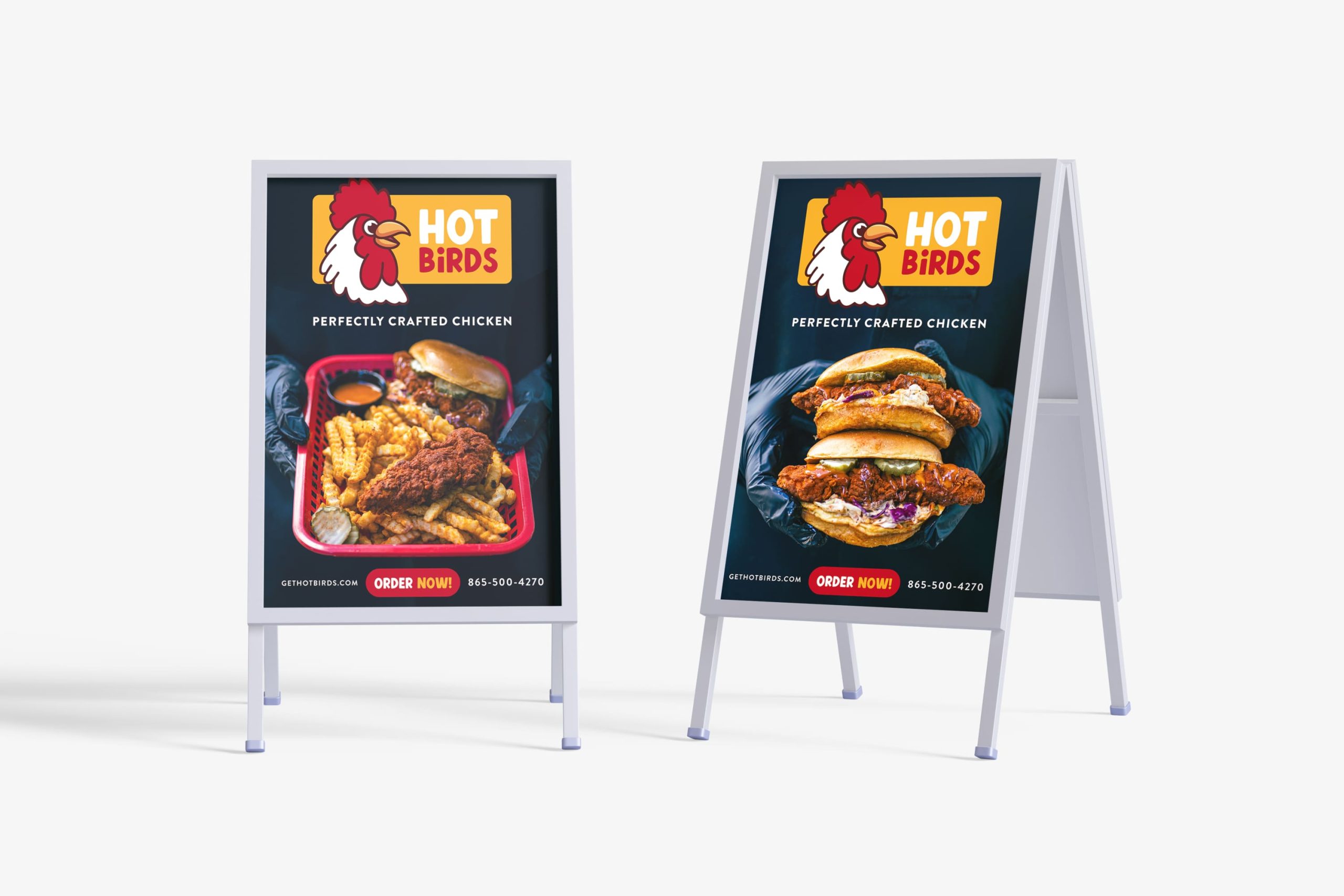 Two white sidewalk A-frame signs featuring high-contrast food photos, the Hot Birds logo, an Order Now button callout, and website URL.