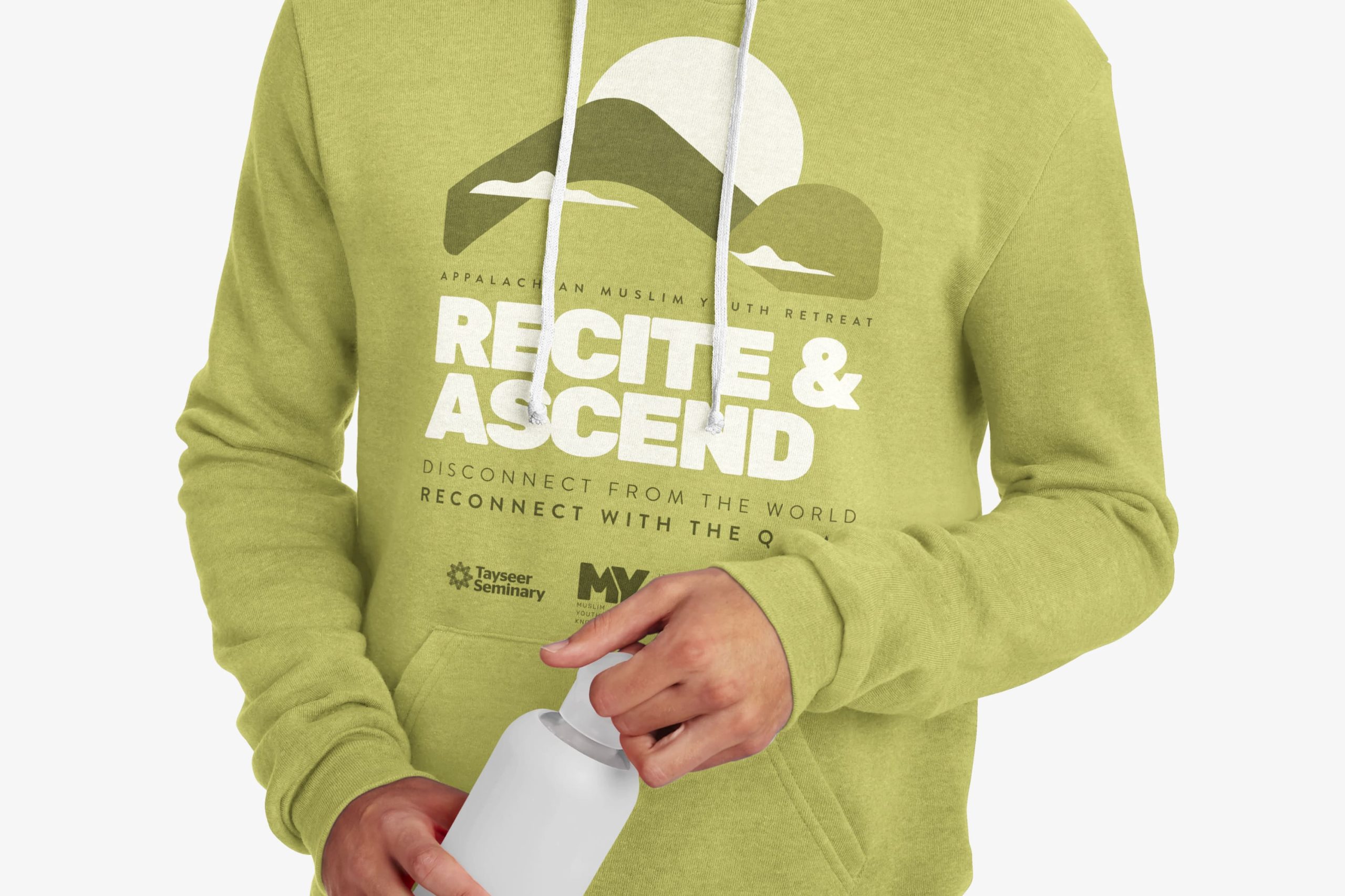 Person wearing a light green hooded sweatshirt printed with the retreat mountain and rising sun emblem alongside Tayseer Seminary and MYK partner logos.