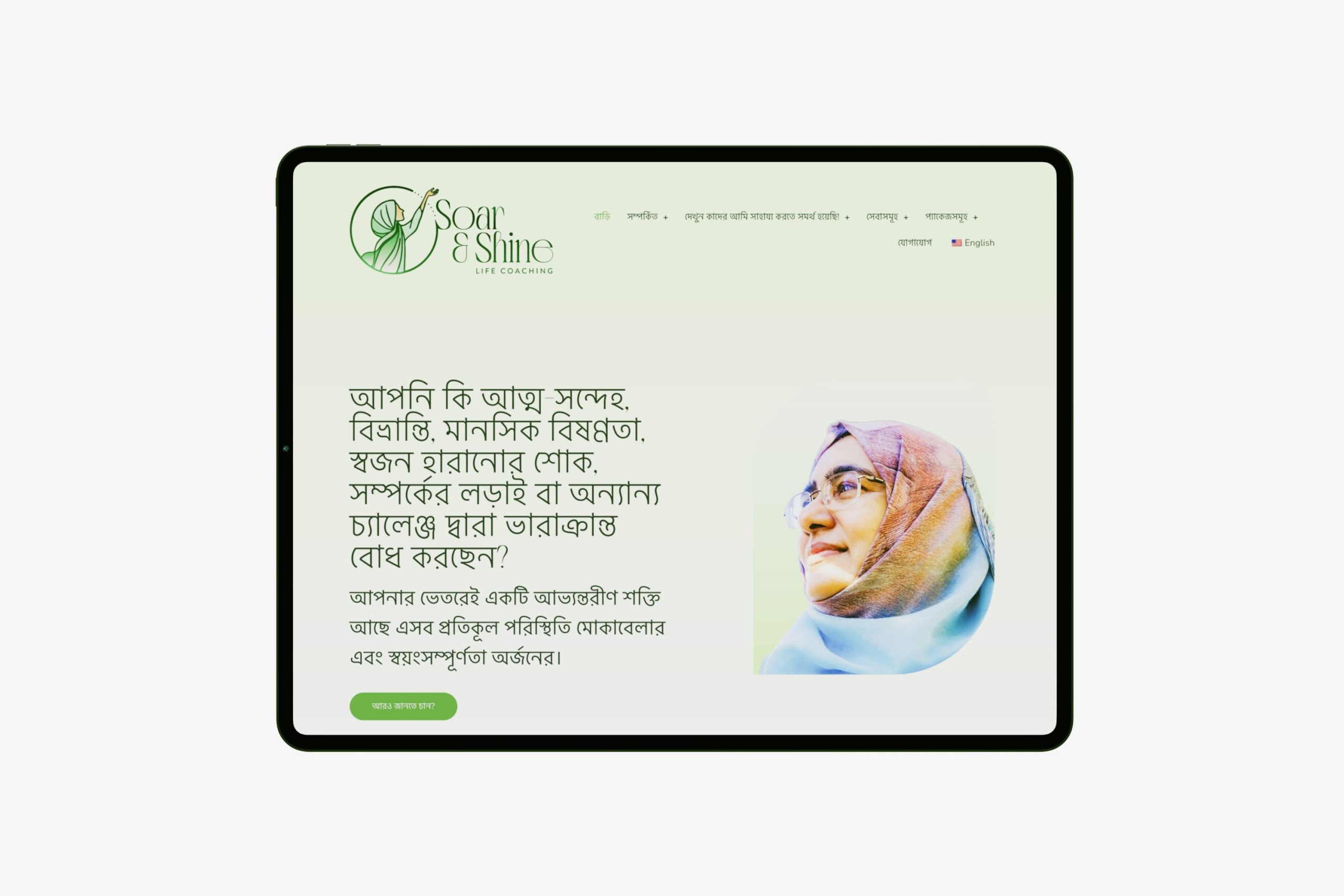 Angled view of a tablet screen displaying the Bengali language version of the Soar & Shine homepage hero section with Bengali typography.